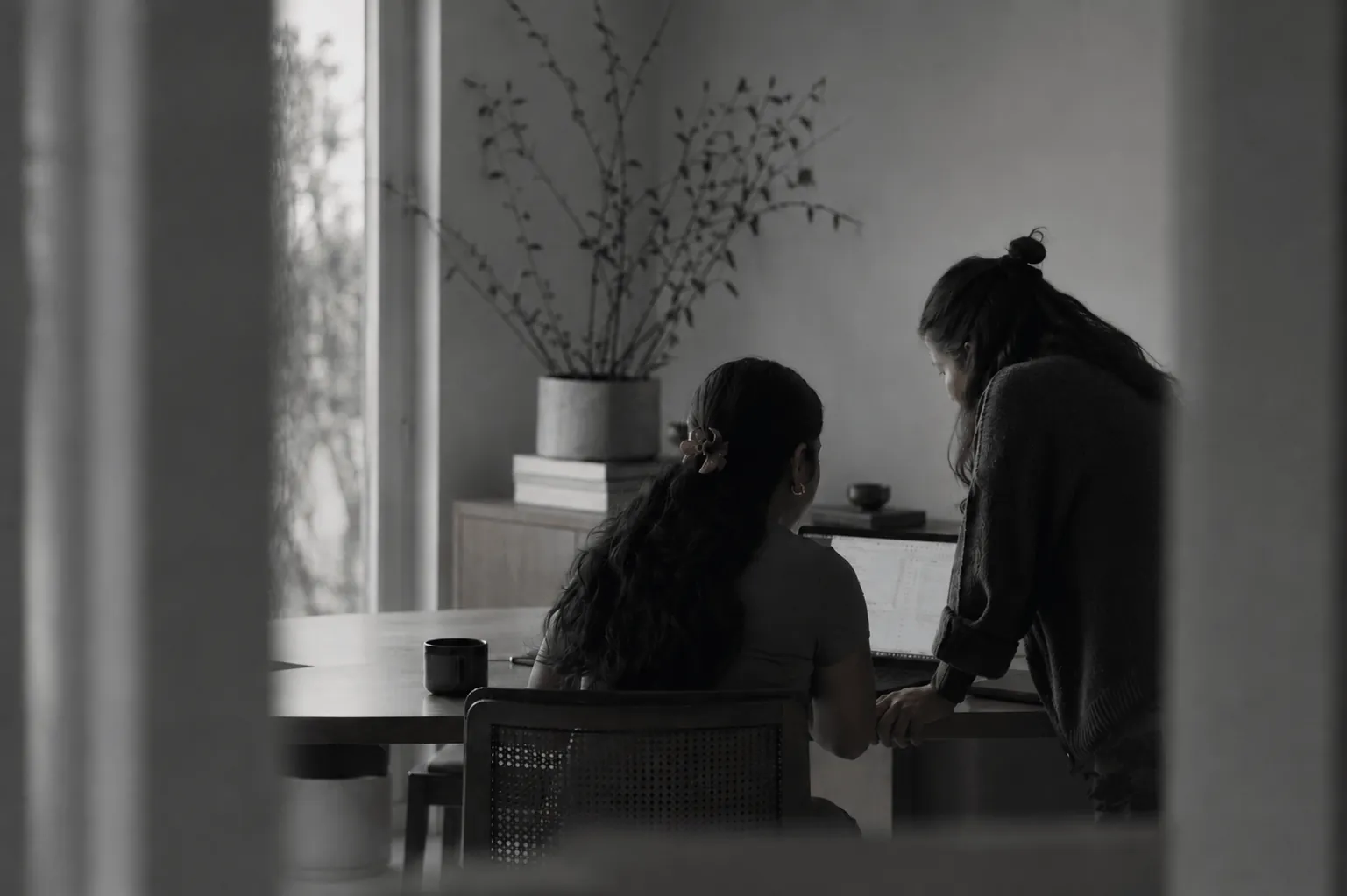 Two colleagues smiling and reviewing work together at a desk